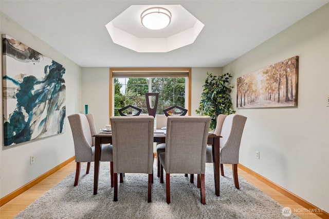 dining space featuring baseboards and light wood-style floors