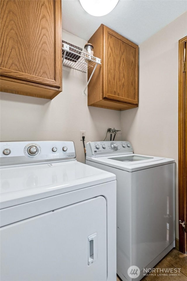 clothes washing area featuring washer and dryer and cabinet space