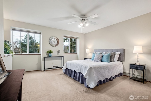 bedroom featuring light colored carpet, baseboards, and ceiling fan