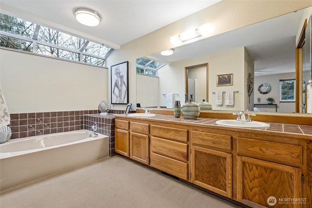 bathroom featuring a bath, a wealth of natural light, and a sink