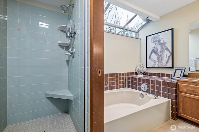 full bathroom with vanity, a garden tub, a skylight, and a shower stall