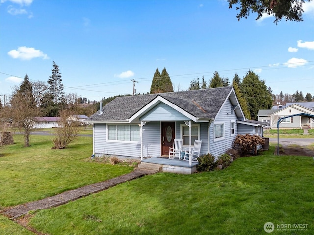 ranch-style house with a front yard, covered porch, and a shingled roof