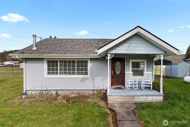 bungalow with a shed, a porch, a shingled roof, and a front yard