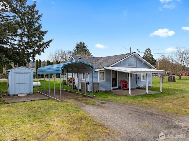 view of front facade featuring a detached carport, a front yard, driveway, an outdoor structure, and a storage shed