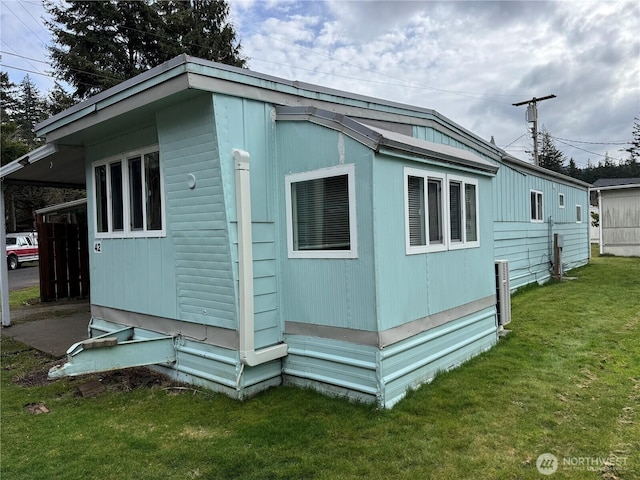 view of side of home with a yard and an attached carport