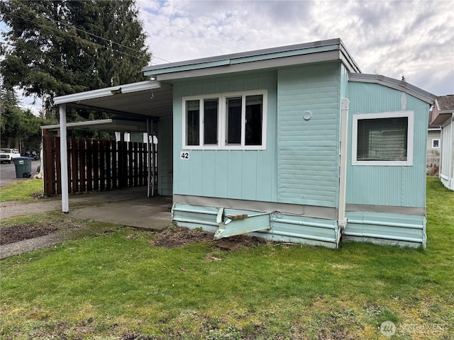 view of side of home featuring a yard and an attached carport