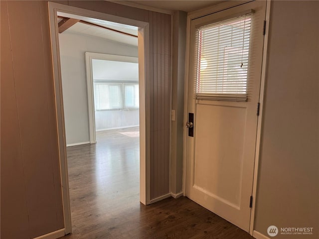 hallway with baseboards and dark wood-type flooring