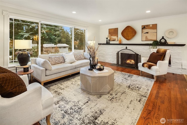 living area featuring recessed lighting, a fireplace with flush hearth, wood finished floors, and crown molding