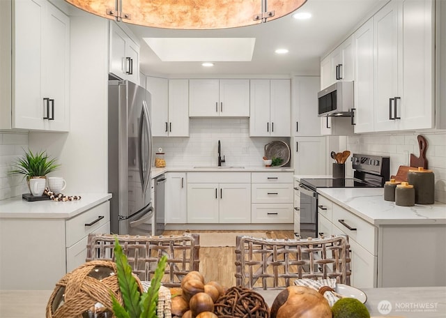 kitchen with a sink, appliances with stainless steel finishes, and white cabinets