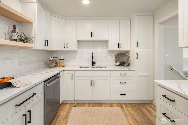 kitchen with light wood-style flooring, a sink, open shelves, stainless steel dishwasher, and white cabinets