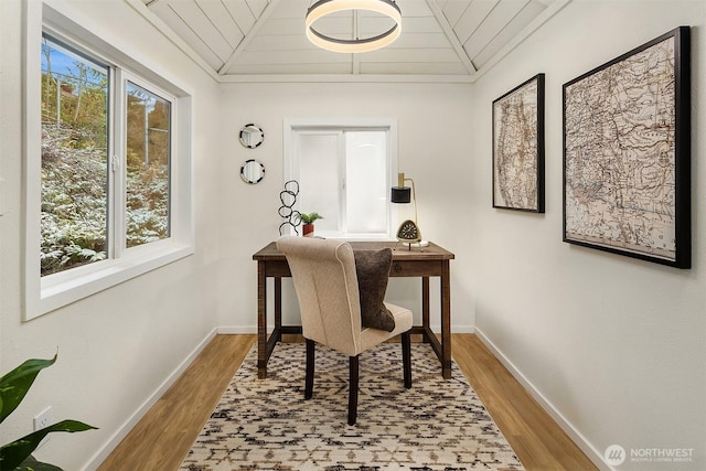 office space featuring a healthy amount of sunlight, lofted ceiling, and wood finished floors