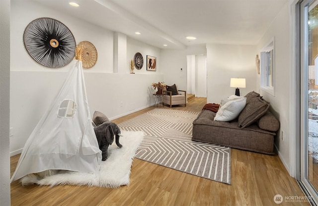 living area featuring recessed lighting, baseboards, and wood finished floors