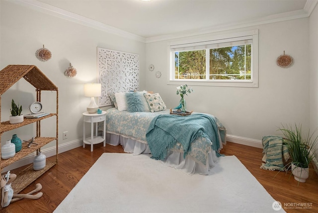 bedroom with baseboards, wood finished floors, and ornamental molding