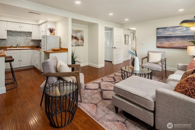 living room featuring dark wood-type flooring, recessed lighting, visible vents, and baseboards