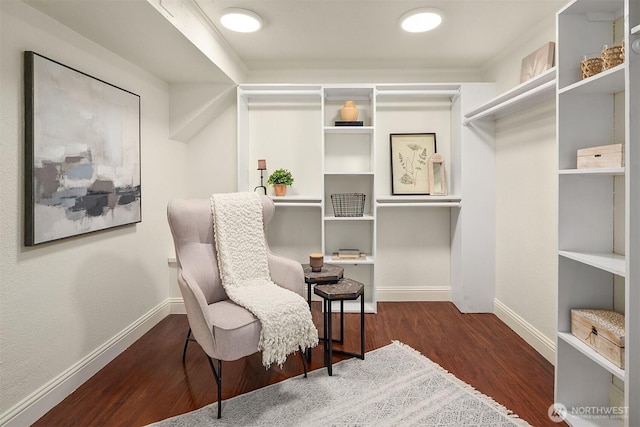 sitting room featuring wood finished floors, baseboards, and ornamental molding