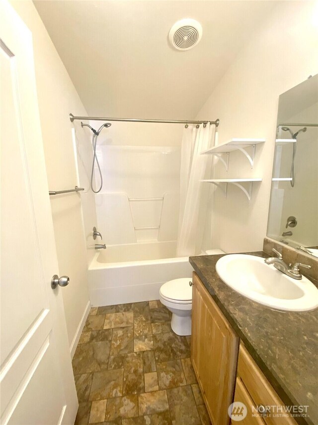 full bathroom with visible vents, shower / bath combination with curtain, toilet, stone finish floor, and vanity