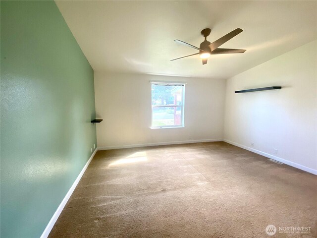 carpeted spare room with lofted ceiling, baseboards, and ceiling fan