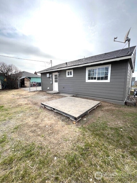 back of property with a yard and a patio