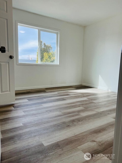 unfurnished room featuring wood finished floors and baseboards