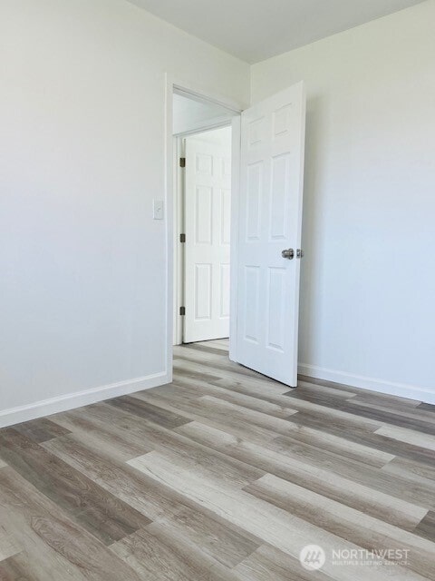 interior space featuring baseboards and wood finished floors