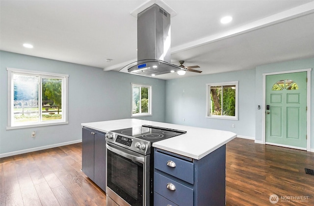 kitchen featuring dark wood-style floors, blue cabinets, island exhaust hood, and stainless steel range with electric cooktop