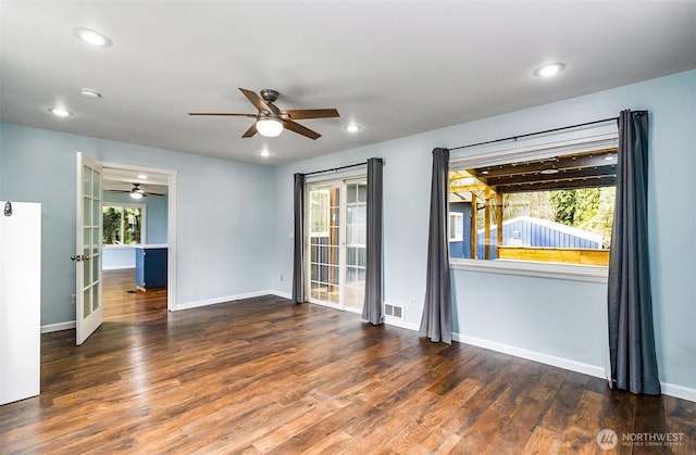 unfurnished room with visible vents, baseboards, wood finished floors, and french doors