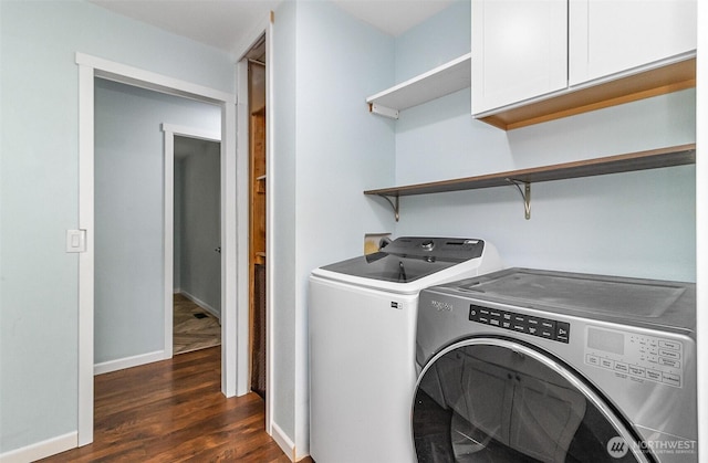 washroom featuring washing machine and dryer, cabinet space, baseboards, and dark wood-style flooring