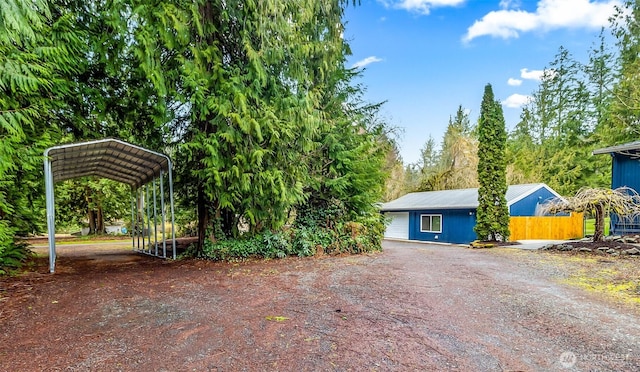 view of yard featuring a detached carport and driveway