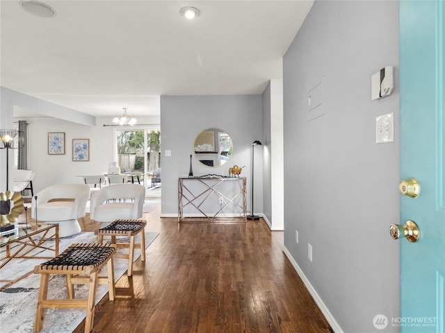 interior space featuring an inviting chandelier, wood finished floors, and baseboards