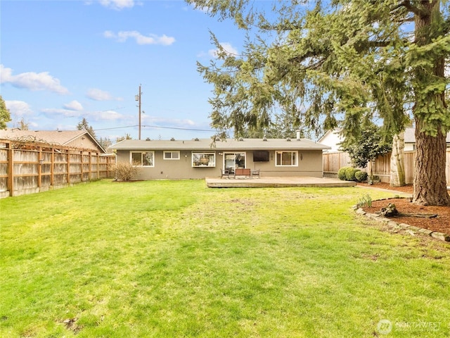 rear view of property with a deck, a lawn, and a fenced backyard