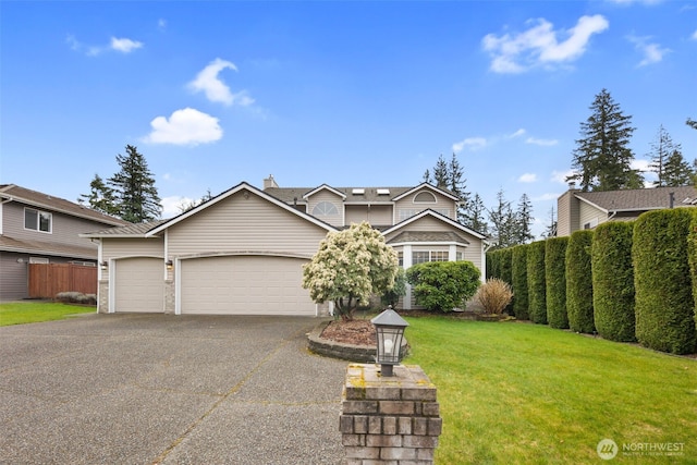 traditional-style home with aphalt driveway, fence, a garage, and a front lawn