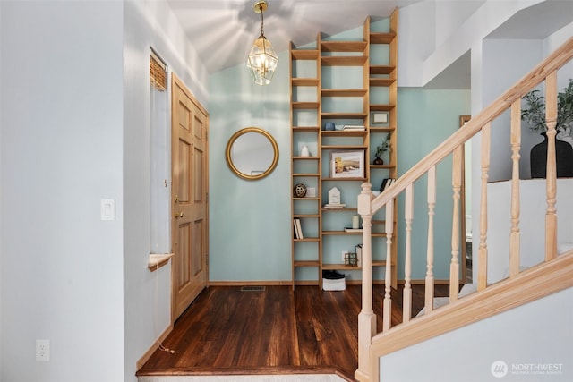 foyer featuring visible vents, wood finished floors, an inviting chandelier, baseboards, and stairs