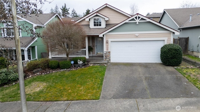 view of front of house featuring a porch, an attached garage, concrete driveway, and a front yard