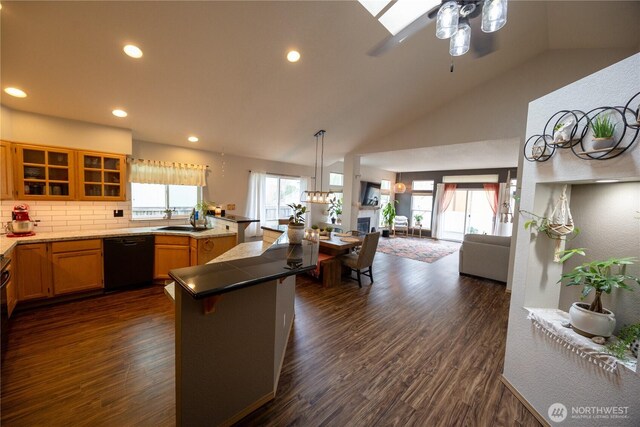 kitchen featuring dishwasher, glass insert cabinets, open floor plan, and dark wood-style flooring