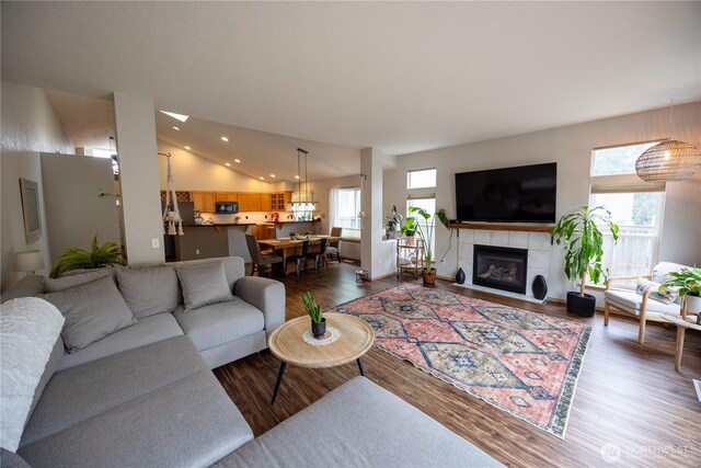 living room with recessed lighting, lofted ceiling, dark wood finished floors, and a fireplace