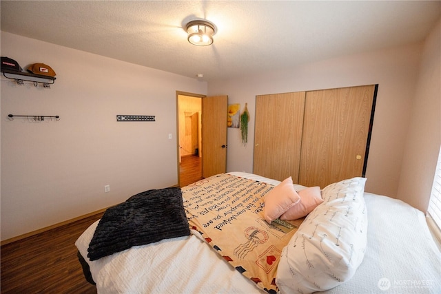 bedroom with a closet, baseboards, and wood finished floors