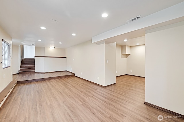 basement with visible vents, baseboards, stairway, recessed lighting, and light wood-style flooring