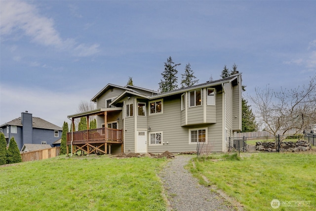 back of house featuring a lawn, a deck, and fence