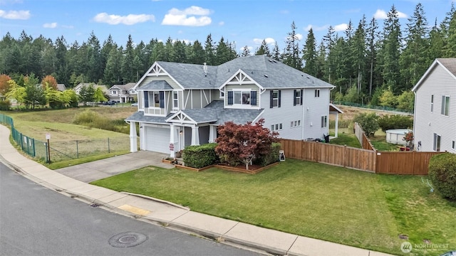 view of front of home featuring a front lawn, fence, roof with shingles, concrete driveway, and a garage