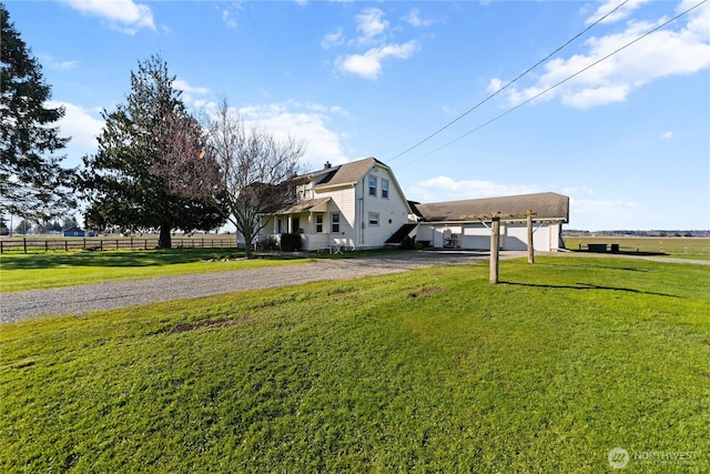 view of yard with a rural view, gravel driveway, and fence