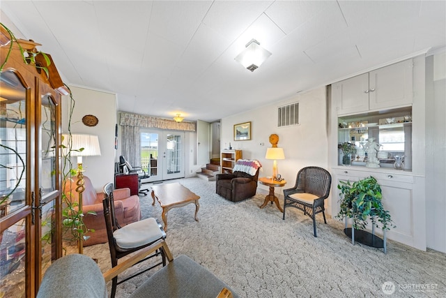 living room featuring french doors, visible vents, and carpet floors