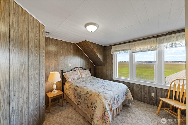 carpeted bedroom featuring wooden walls and visible vents