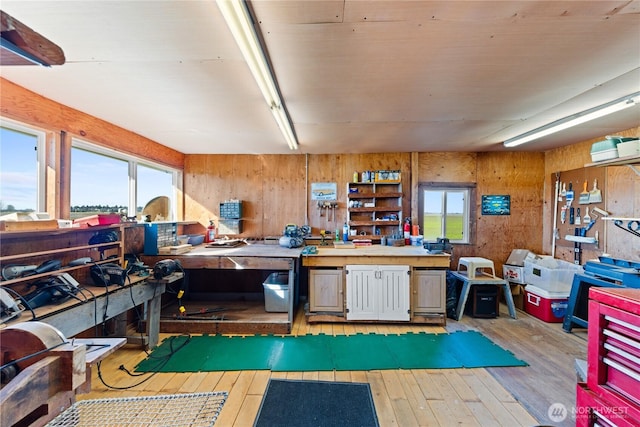 miscellaneous room with a workshop area, wood walls, and hardwood / wood-style floors