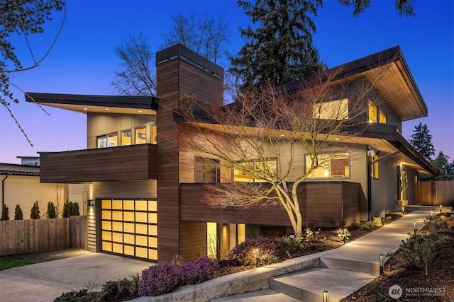 contemporary house featuring a balcony, driveway, a garage, and fence