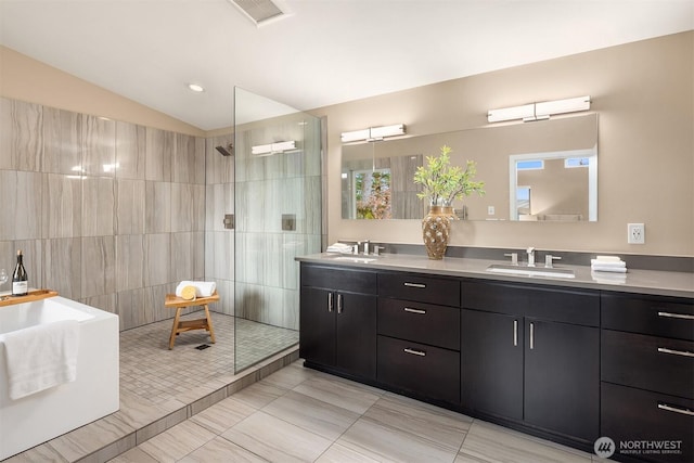 full bathroom with vaulted ceiling, a walk in shower, and a sink