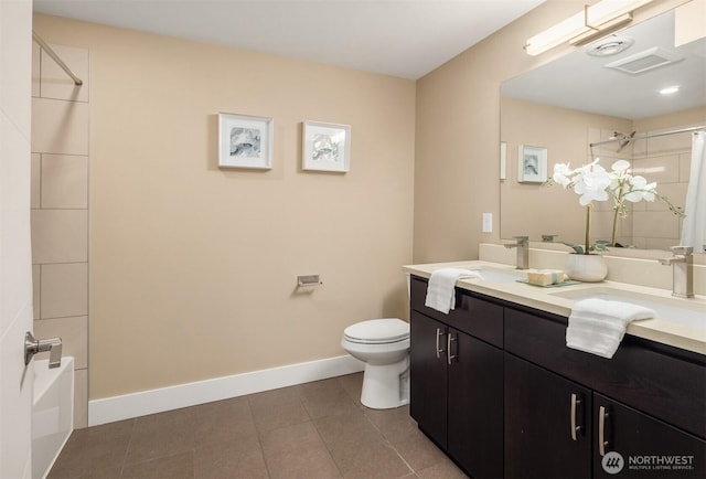 bathroom featuring baseboards, double vanity, a sink, tile patterned floors, and toilet