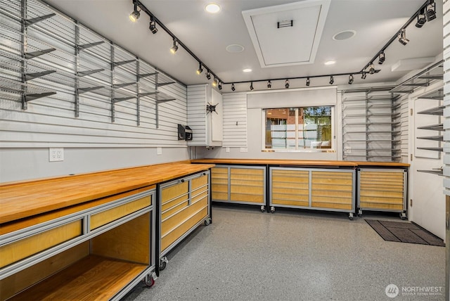 bar featuring rail lighting and dark speckled floor