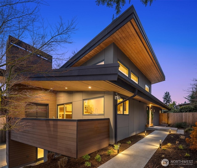 property exterior at dusk featuring fence