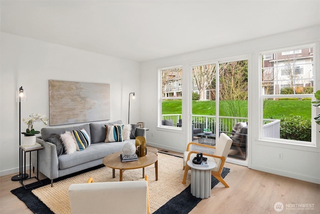 living area featuring light wood-style flooring and baseboards