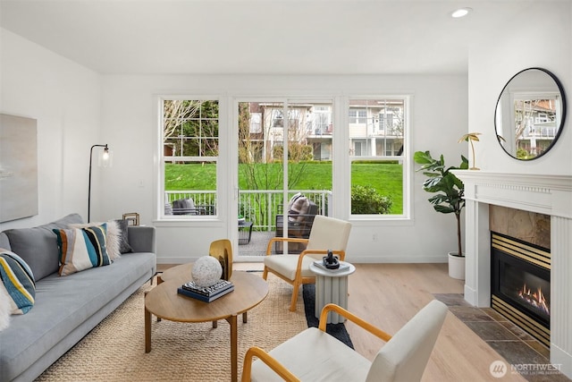 living room with recessed lighting, baseboards, wood finished floors, and a tiled fireplace